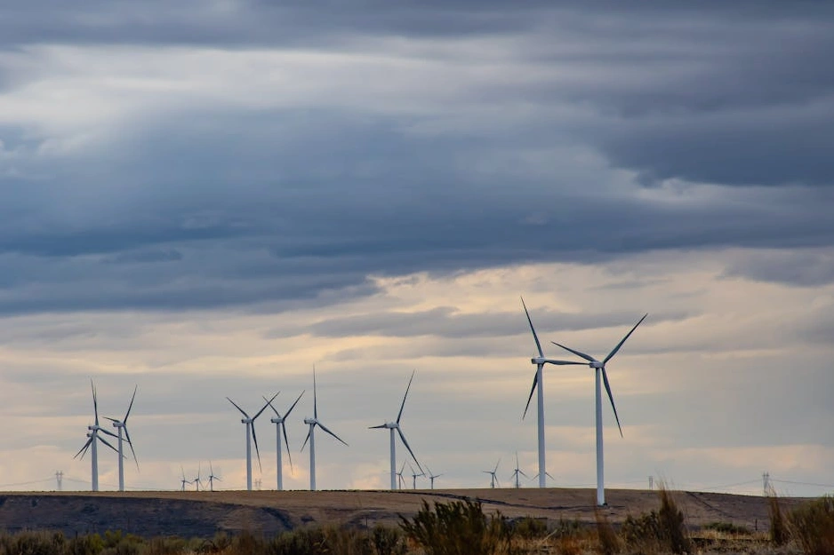 Modern wind turbines against a clear blue sky, representing renewable energy.